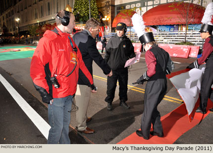 Macy's executive producer Wesley Whatley and Dobyns-Bennett director Lafe Cook give the banner carriers precise instructions at the starting line. 2011 Macy's Thanksgiving Day Parade Photo by Marching.com