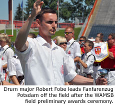 Drum major Robert Fobe leads Fanfarenzug Potsdam off the field after the WAMSB field preliminary awards ceremony. Photo by Marching.com