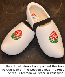 Parent volunteers hand painted the Rose Parade logo on the wooden shoes The Pride of the Dutchmen will wear in Pasadena.