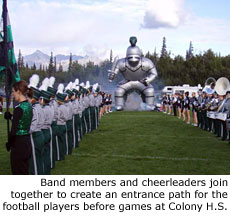 Band members and cheerleaders join together to create an entrance path for the football players before games at Colong H.S.